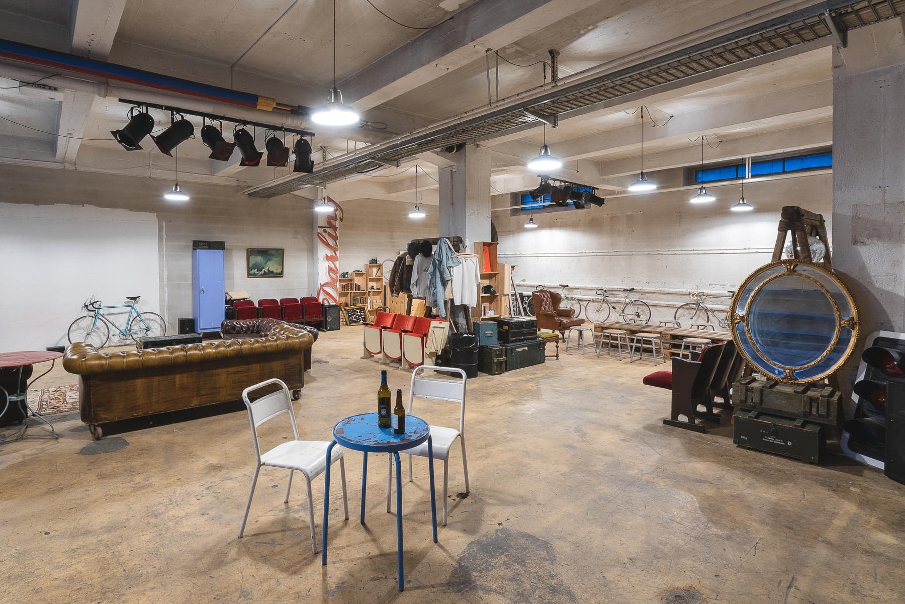 Intérieur d'entrepôt de 240m² mettant en valeur la lumière naturelle à travers de grandes fenêtres, plafond industriel exposé et espace ouvert polyvalent parfait pour événements privés, expositions et célébrations à Lausanne